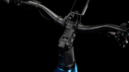 Nahaufnahme eines CUBE Kathmandu Hybrid EX 800 electricblue´n´chrome 2025-Lenkers mit montierter Digitalanzeige, Gangschaltung und Teil des Rahmens vor einem schwarzen Hintergrund.