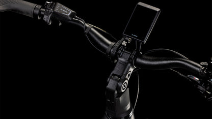 Nahaufnahme des CUBE Kathmandu Hybrid EXC 800 black'n'prism Trapeze 2025 Lenkers mit Bosch-Digitalanzeige, Bedientasten, strukturiertem Griff und Bremshebel vor schwarzem Hintergrund.
