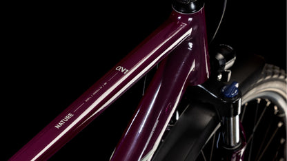Nahaufnahme des Cube Nature ONE Allroad amarone'n'lunar 2025 Rahmens von CUBE mit weißen Akzenten, "NATURE" Branding, Oberrohransicht, Federgabel und Shimano 1x8-Gang Schaltung auf schwarzem Hintergrund.
