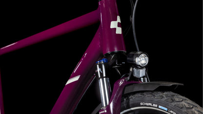 Nahaufnahme der Frontpartie des CUBE Nature ONE Allroad amarone'n'lunar 2025, die den Rahmen, die Shimano 1x8-Gang-Schaltung, die Federgabel, den Scheinwerfer, das Schutzblech und den Schwalbe-Reifen vor einem schwarzen Hintergrund zeigt.