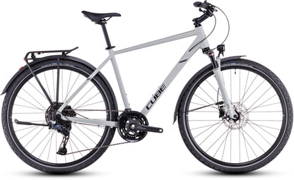 Ein CUBE Cube Nature EXC Allroad Hybrid-Fahrrad in Seasalt'n'Pyrit mit Aluminiumrahmen, Vorderradaufhängung, Shimano Cues-Schaltung, schwarzem Lenker, Gepäckträger und Schutzblechen; dargestellt in der Seitenansicht auf weißem Hintergrund.