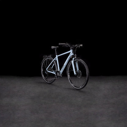 Das CUBE Nature EXC Allroad pigeonblue'n'black Elektrofahrrad mit schwarzen Reifen, Lenker und hydraulischen Scheibenbremsen ist in einem leichten Seitenwinkel auf einem dunklen, neutralen Hintergrund abgebildet.