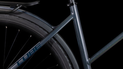 Nahaufnahme des Cube Kathmandu SLX nightsky'n'ink Trapeze 2025 von CUBE, ausgestattet mit Shimano Cues 2x11-Gang Schaltung und Hinterradgepäckträger - dargestellt vor einem schwarzen Hintergrund für nachhaltige Mobilität.