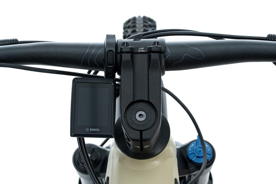 Nahaufnahme eines Fahrradlenkers mit einer Bosch KIOX 300 Anzeige auf der linken Seite, blauen Einstellknöpfen und einer ACID Halterung für Bosch KIOX 300/500 von ACID vor einem weißen Hintergrund.
