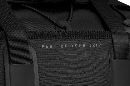 Nahaufnahme der ACID Lenkertasche PACK PRO 15 schwarz von ACID, mit stabilen Riemen und "PART OF YOUR TRIP" in kleinen weißen Buchstaben - perfekt für urbane Abenteuer in Städten wie Göttingen oder Goslar.